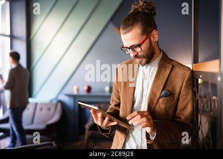 Young handsome businessman holding tablet working, relaxing Stock Photo