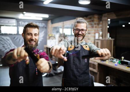 Portrait of young male barbers and hairdressers in barber shop