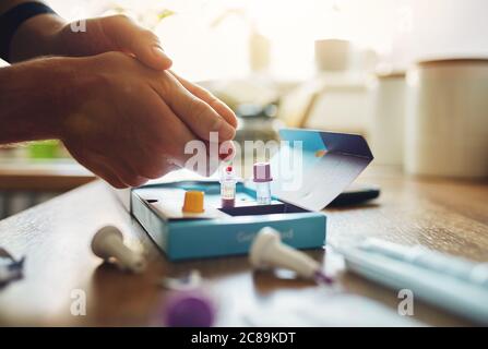 Home blood DNA COVID-19 test with blood on finger. Stock Photo