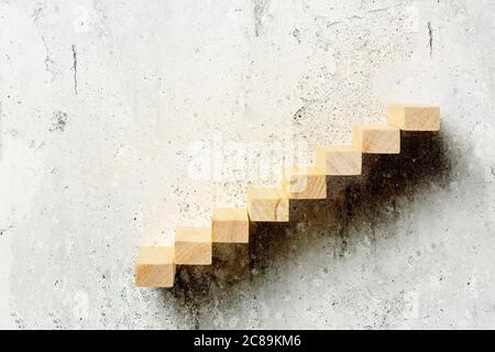 wooden toy blocks as staircase on grungy wall, abstract concept Stock Photo