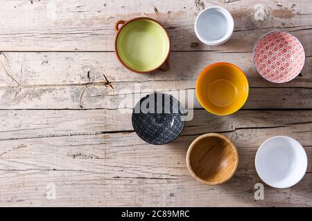 Set of different empty bowls on wooden background Stock Photo