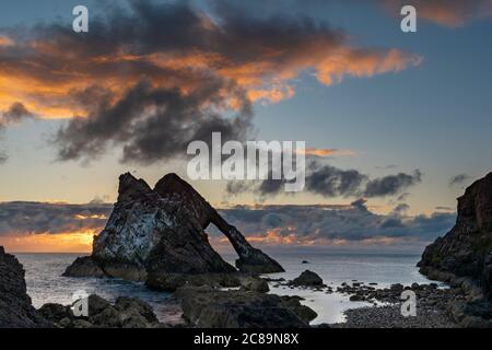 BOW FIDDLE ROCK PORTKNOCKIE MORAY COAST SCOTLAND A JULY SUNRISE COLOURFUL CLOUD FORMATION OVER THE ROCK Stock Photo