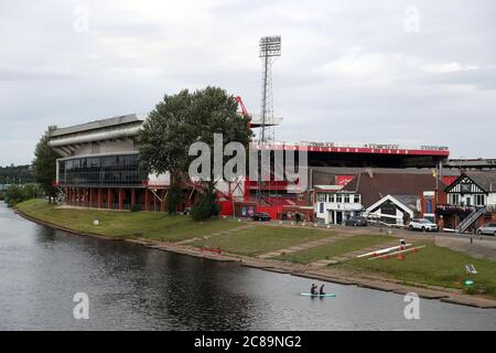 Paddle boarders passes the City Ground on the banks of the River Trent ahead of the Sky Bet Championship match at the City Ground, Nottingham. Stock Photo