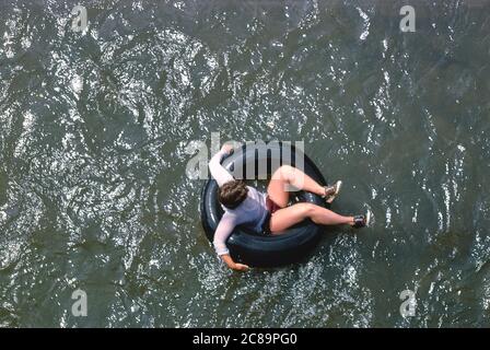 Young Woman floating in Inner Tube, High Angle View, Phoenicia, New York, USA, John Margolies Roadside America Photograph Archive, 1978 Stock Photo