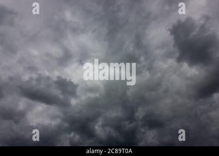 Dramatic sky during sunset. Dark storm clouds with black and white highlights. Stock Photo