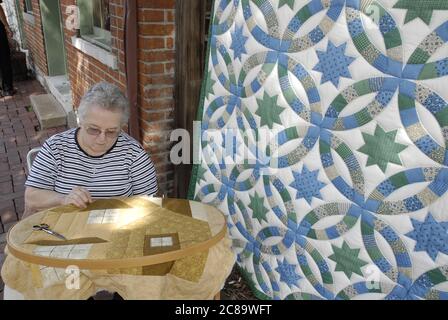 ST. CHARLES, UNITED STATES - Sep 12, 2008: A woman working on a quilt at an outdoor quilt show in St. Charles, Missouri Stock Photo