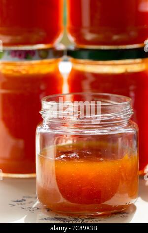 Canned apricot jam in glass jars on the windowsill. Stock Photo