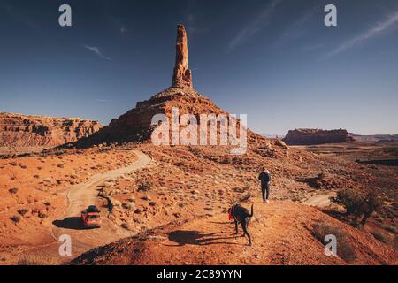 A woman with a child and a dog Is standing on a hill at Valley of Gods