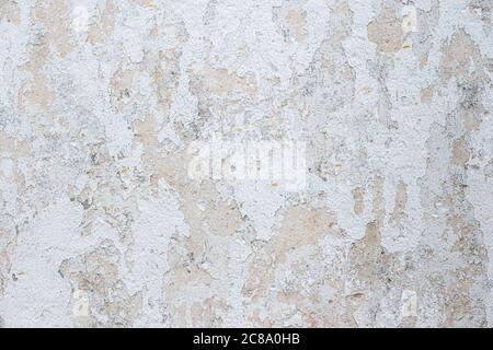 Old wall with peeling paint white. Old textured concrete wall painted white color. Stock Photo