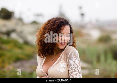 Young Woman in Sheer Dress Smiling on Beach Stock Photo