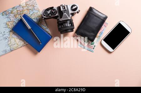 Conceptual still life with various objects related to travel on pink background. Stock Photo