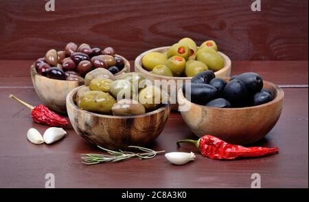 Olives in the wooden bowls with spicy on the wood table Stock Photo
