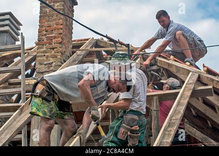 Zrenjanin, Serbia, July 22, 2020. A group of masters is working on the roof of a private house to replace an old tile. They use a nice day and stable Stock Photo