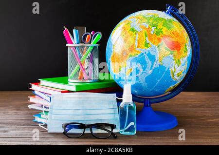 Back to school during quarantine. Education concept. School supplies with medical mask and sanitizer. Stock Photo