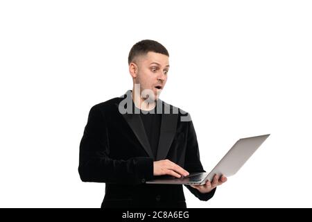 Side profile view portrait of confident surprised shocked handsome cheerful man dressed in classic elegant suit using netbook for work Stock Photo