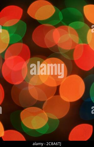 Vertical Image of Abstract Blurred Multi-color Glittering Illuminated Light on Black Background Stock Photo