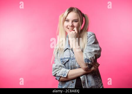 Pretty happy student girl with hair formed ponytails, having fun and flirting with us Stock Photo