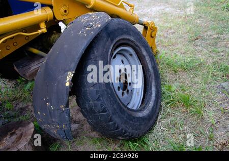 Old rusty tractor's flat back tire. industrial Stock Photo