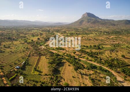 Nzaui rock rises above farmland, orchards and seasonal rivers in Makueni County, Kenya, East Africa. Stock Photo