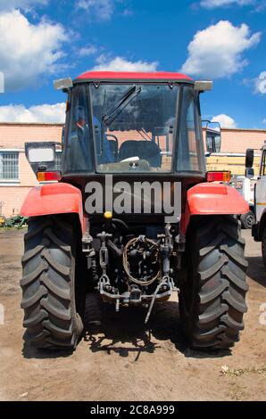 Old rusty tractor's flat back tire. Stock Photo