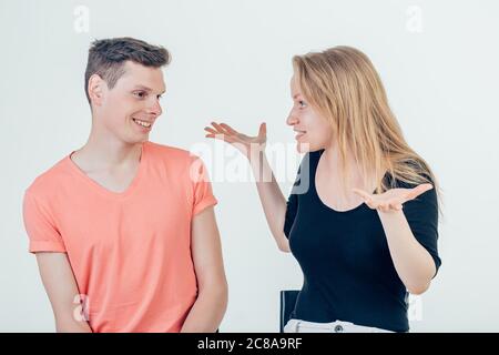 Half length portrait of young couple standing against white background shrugging their shoulders having uncertainty not knowing what to do. Pretty wif Stock Photo