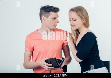 Nerdy man is trying to hide money from his wife because she want to spend it all.Terrified nerdy man hiding wallet from his wife Stock Photo