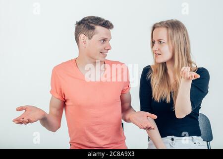 Half length portrait of young couple standing against white background shrugging their shoulders having uncertainty not knowing what to do. Pretty wif Stock Photo