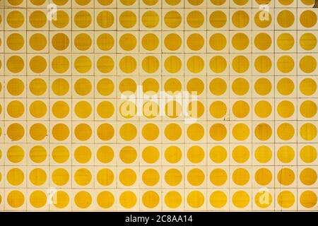Facade of an old house with square tiles with yellow circles. Image for backgrounds or designs Stock Photo