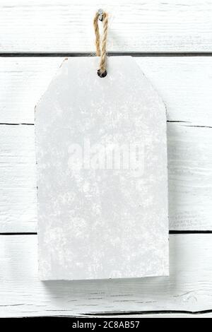 white wooden signboard with grungy texture hanging on weathered planks Stock Photo