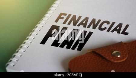 Financial Plan words on copybook page and wallet. Investment business Concept Stock Photo