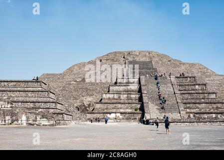 TEOTIHUACAN, Mexico — The expansive view from the plaza in front of the Pyramid of the Moon at Teotihuacan. This vantage point offers a striking perspective of the ancient city's main thoroughfare, the Avenue of the Dead, stretching southward, flanked by smaller pyramids and platforms, with the massive Pyramid of the Sun dominating the eastern skyline. Stock Photo