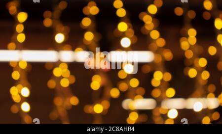 Blurry lights of urban Christmas illumination. Golden bokeh, abstract background, horizontal banner Stock Photo