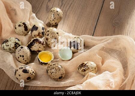Composition of several quail eggs on decorative fabric on a wooden table close-up, flatlay Stock Photo
