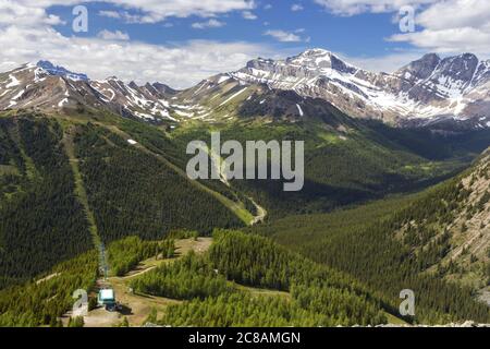 Lake Louise Ski Area Chairlift with Alberta Summertime Landscape Scenic Aerial Mountain Tops Horizon in Banff National Park, Canadian Rockies Stock Photo