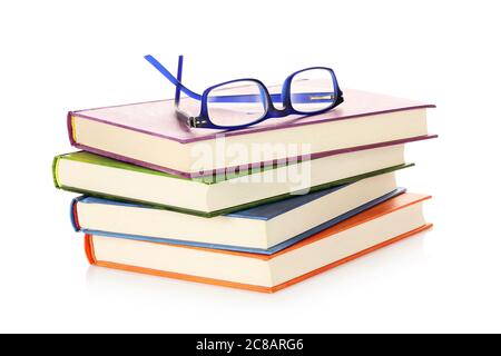 stack of colorful books with reading glasses on them isolated Stock Photo