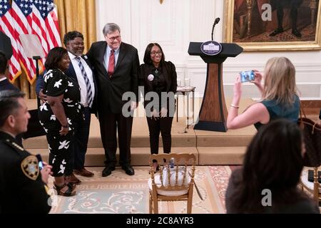 United States Attorney General William P. Barr poses for a photo in the East Room with the family of LeGend Taliferro following remarks from US President Donald J. Trump on 'Operation Legend: Combatting Violent Crime in American Cities' at the White House in Washington, DC, U.S., on Wednesday, July 22, 2020. Taliferro was killed by gun violence in Kansas City, Missouri. Credit: Sarah Silbiger/Pool via CNP/MediaPunch Stock Photo