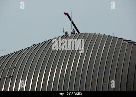 Roof repair construction workers with a building crane on a design project in Thailand. Stock Photo