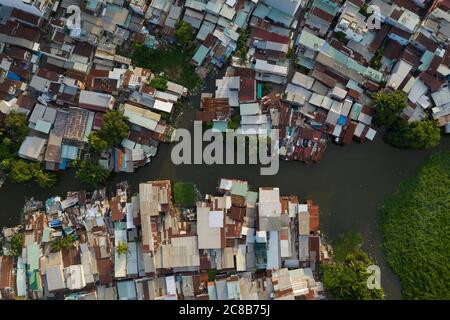 rooftops old residential and business area resembling a crowded shanty town built along a canal from aerial top down view