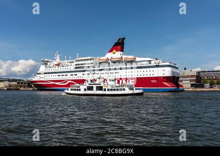 Suomenlinna ferry Suokki passing moored cruise ship M/S Gabriella of Viking Line in Helsinki, Finland
