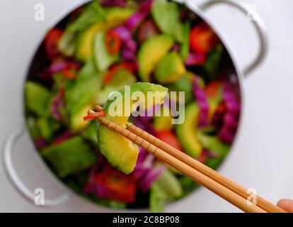 Vietnamese vegetarian cuisine, mixed vegetable from avocado, salad, tomato, violet cabbage with soy sauce, lemon, chili, nutrition vegan dish Stock Photo