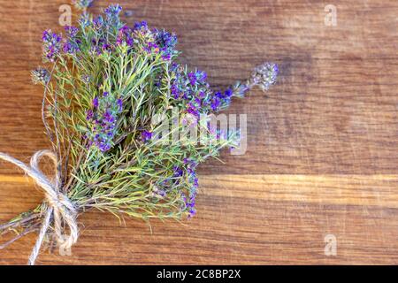 A bunch of fresh thyme lies on an old wooden background. Top view, flat lay. Fresh herb. Selective focus, copy space Stock Photo