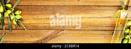 olive oil and branch with olives on old wooden surface Stock Photo