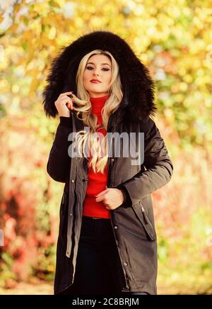 Classic parka coat has become wardrobe icon. Versatile functional and  stylish. Girl wear parka while walk park. Puffer jacket with hood. Woman  wear black parka fur hood. Youth hipster fashion concept Stock