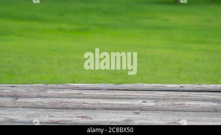 Wood deck and blur nature green grass background. Stock Photo