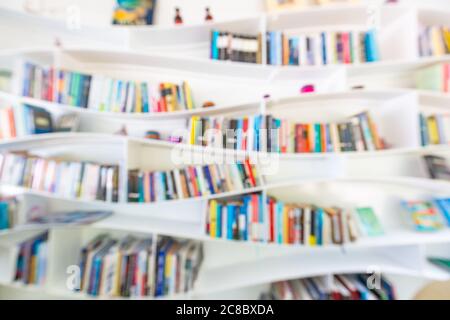 Abstract blurred bookshelves with books, manuals and textbooks on bookshelves in library or in book store, soft focus. Concept of learning, school Stock Photo