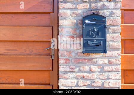 Brown mailbox on brick wall, vintage mailbox style. Stock Photo
