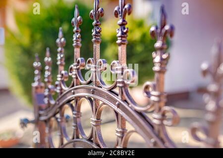 Pointed metal fence perspective. Metal black fence with gold elements Stock Photo