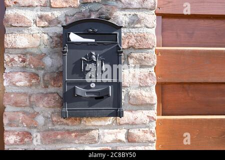 Brown mailbox on brick wall, vintage mailbox style. Stock Photo