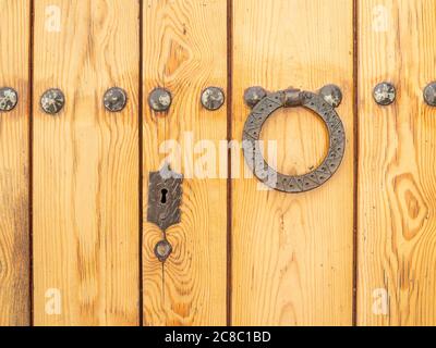 Antique door handle at the wooden door surface Stock Photo