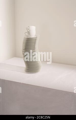 Stack of plates and cups on table Stock Photo